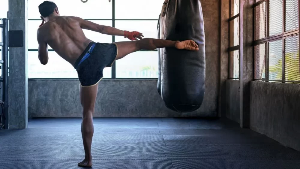 Image-of-a-man-practicing-calf-kicks-with-a-sandbag