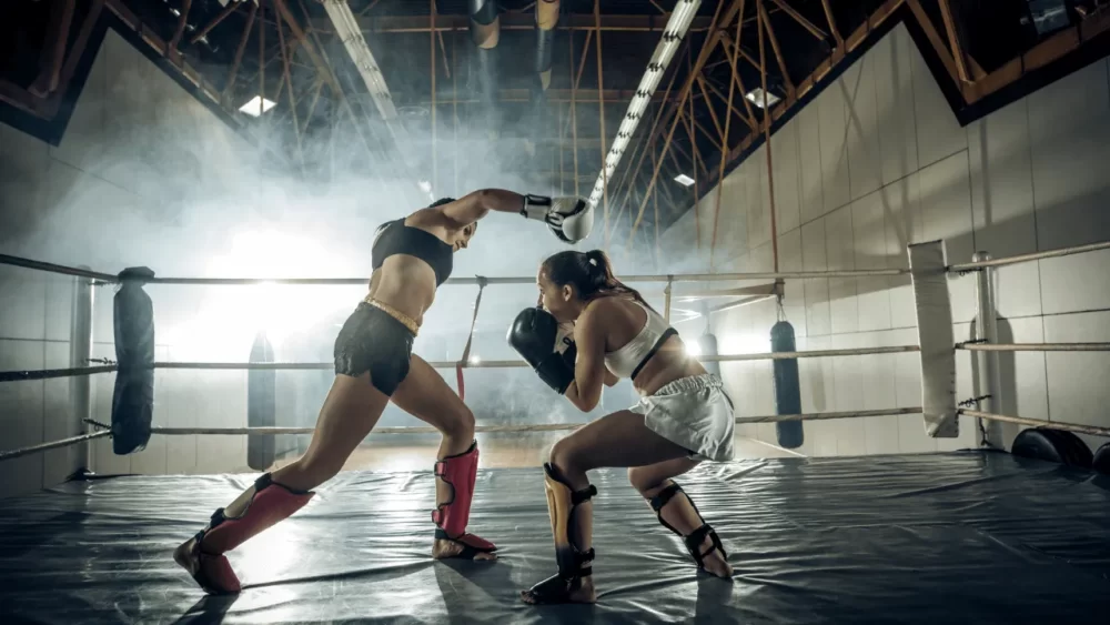 キックボクシングの試合で相手のパンチを避けている女性の画像